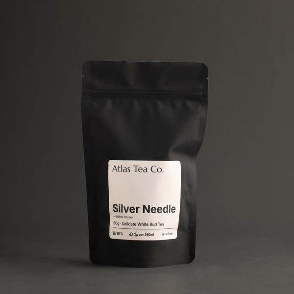 Black tea packaging for Silver Needle with 'Atlas Tea Co.' label on a dark background